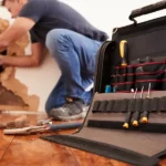 A man is working on a pipe in a room for a condo association.