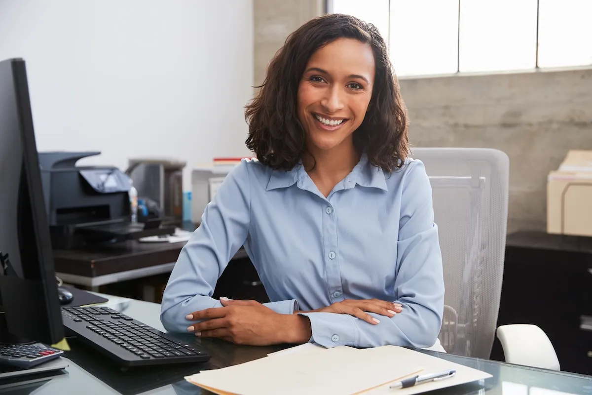 smiling-woman-at-office-desk-ready-to-work-2026-01-05-06-27-06-utc-1200x800